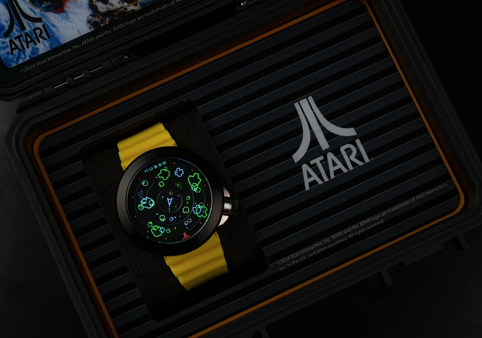 Reloj temático con asteroides con una banda amarilla en una marca Atari.